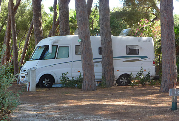 Camping-car sur un emplacement ombragé. Camping les Pins Maritimes